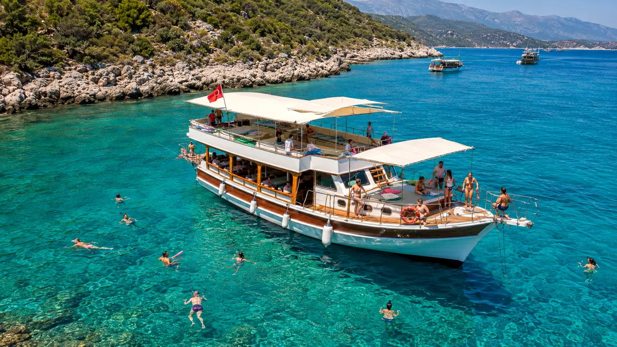 Paylaşımlı Kekova teknesi turkuaz bir koyda misafirlerle